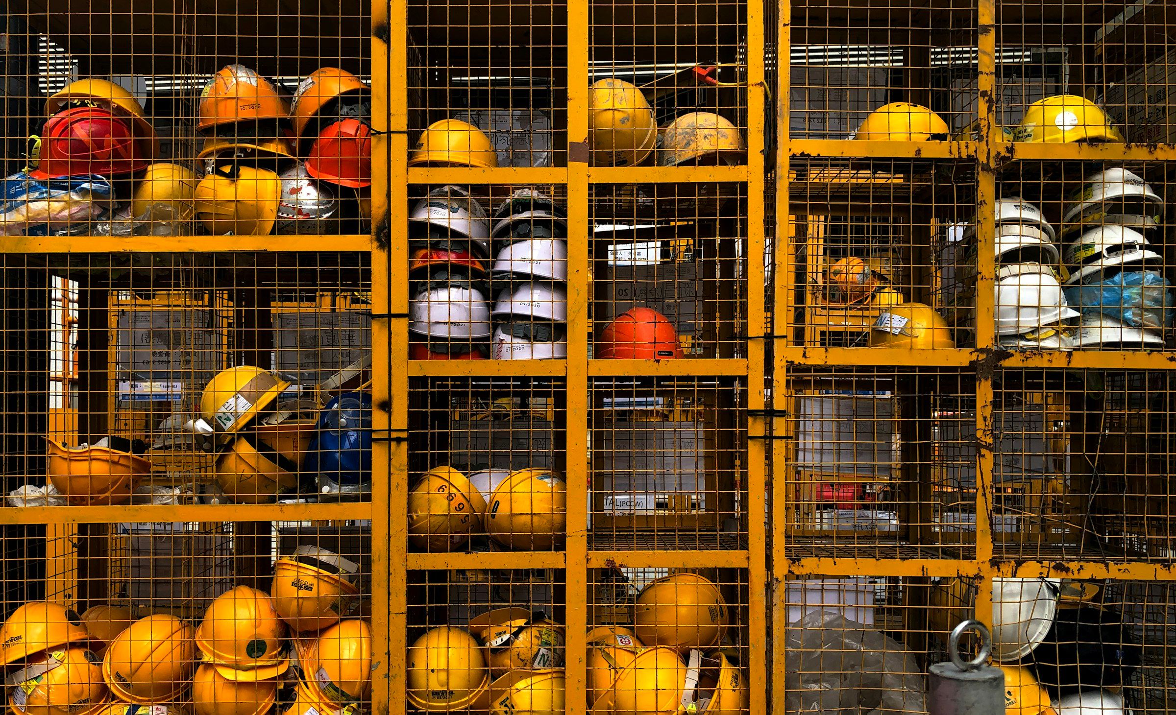 Des casques de sécurité rangés dans un casier grillagé (photo d’illustration)